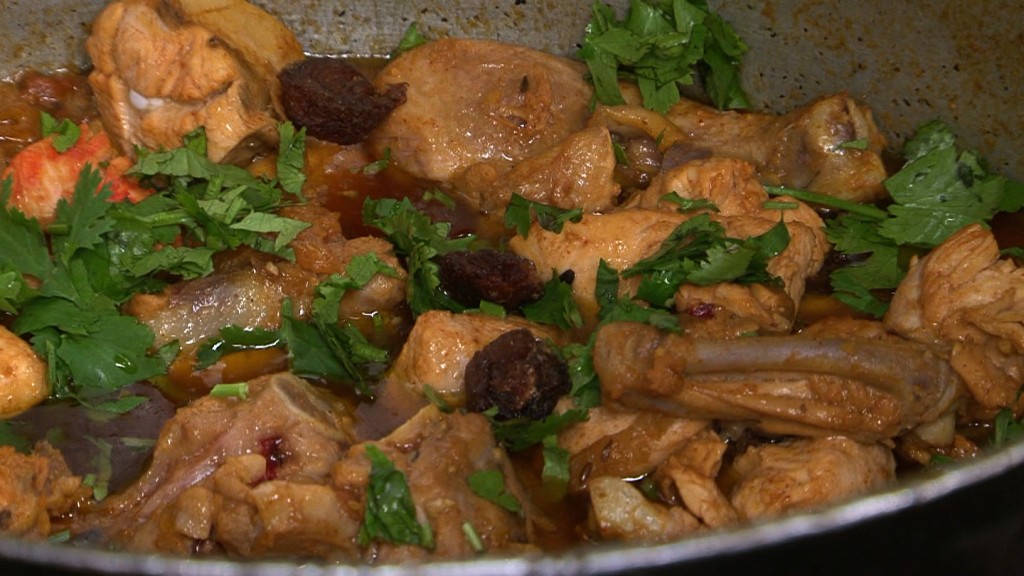 Chicken biryani ingredients being added to the pot at the Pakistani restaurant