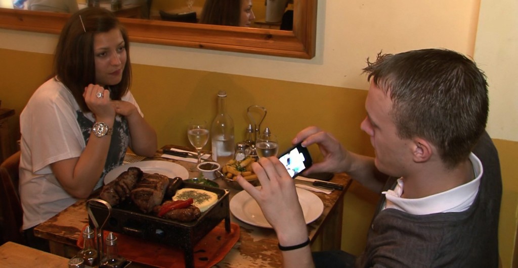 A customer in the Argentinian restaurant takes a photo of his meal.